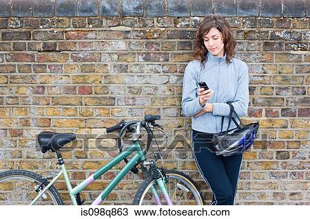 Woman with bike and cellphone View Large Photo Image Stock Image - Woman with bike and cellphone. Fotosearch