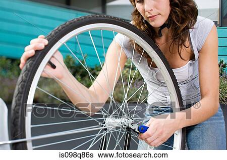 Woman with bike wheel View Large Photo Image Stock Photograph - Woman with bike wheel. Fotosearch
