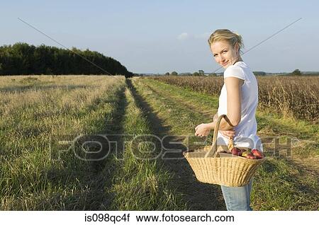 Woman in field with basket View Large Photo Image Stock Image - Woman in field with basket. Fotosearch
