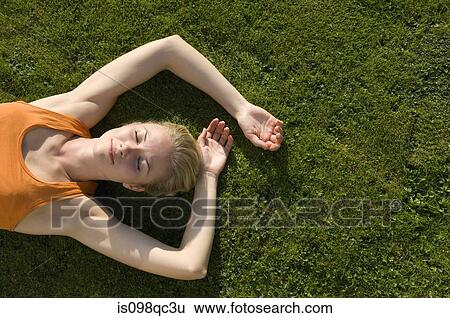 Woman lying on grass View Large Photo Image Stock Photograph - Woman lying on grass. Fotosearch
