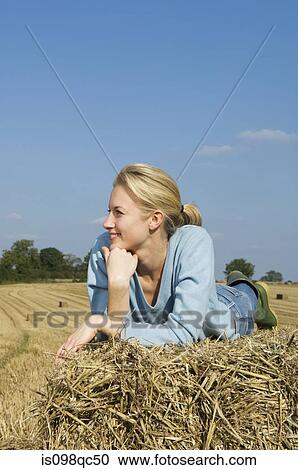 Woman lying on hay bale View Large Photo Image Stock Image - Woman lying on hay bale. Fotosearch