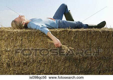 Woman lying on hay bale View Large Photo Image Stock Photograph - Woman lying on hay bale. Fotosearch