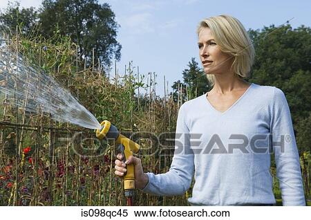Stock Photography - Woman with hose pipe. Fotosearch