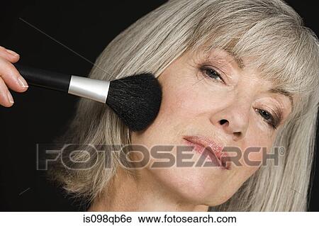 Stock Image - Senior woman applying make up. Fotosearch