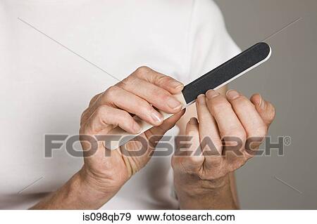 Woman filing her nails View Large Photo Image Stock Photo - Woman filing her nails. Fotosearch