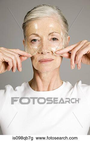 Stock Image - Woman using face mask. Fotosearch