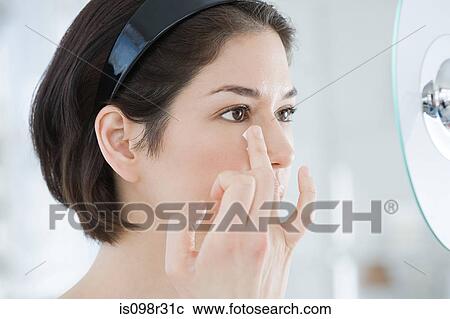 Stock Image - Woman applying moisturiser. Fotosearch