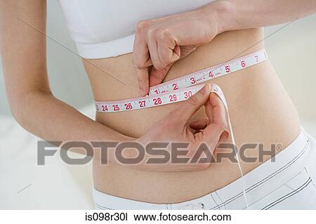 Woman measuring waist View Large Photo Image Stock Image - Woman measuring waist. Fotosearch