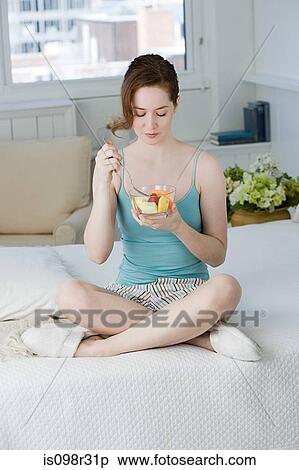 Young woman eating fruit View Large Photo Image Stock Photography - Young woman eating fruit. Fotosearch