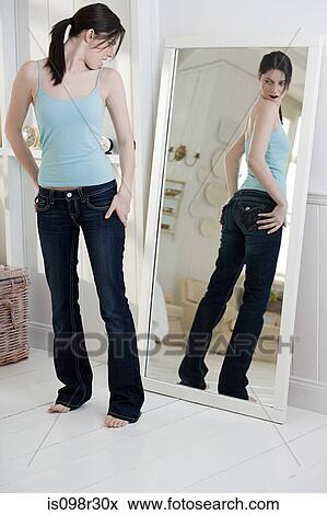 Young woman looking at bottom in mirror View Large Photo Image Stock Photo - Young woman looking at bottom in mirror. Fotosearch