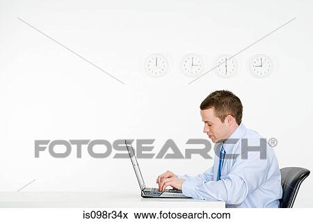 Office worker with laptop and wall clocks View Large Photo Image Stock Photo - Office worker with laptop and wall clocks. Fotosearch