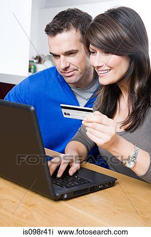 Couple with laptop and credit card View Large Photo Image Stock Image - Couple with laptop and credit card. Fotosearch