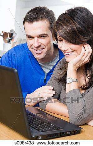 Couple with laptop View Large Photo Image Stock Photo - Couple with laptop. Fotosearch