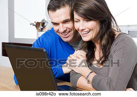 Happy couple with laptop View Large Photo Image Picture - Happy couple with laptop. Fotosearch