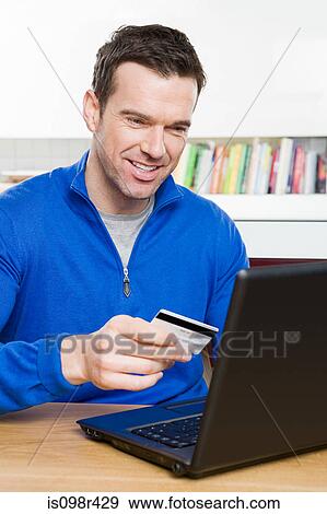 Man with credit card and laptop View Large Photo Image Stock Photo - Man with credit card and laptop. Fotosearch