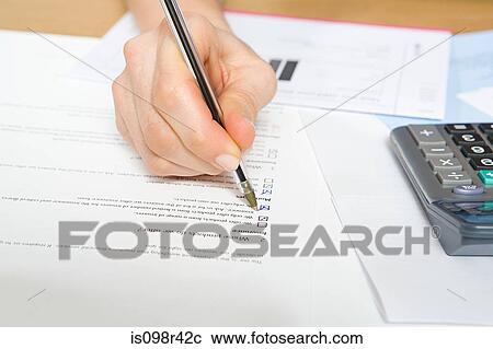 Stock Image - Person filling in form. Fotosearch