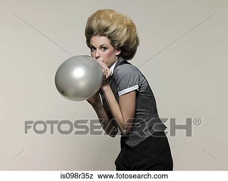 Businesswoman blowing balloon View Large Photo Image Stock Photo - Businesswoman blowing balloon. Fotosearch