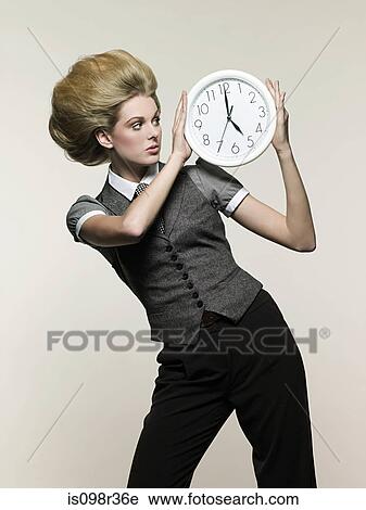 Businesswoman holding clock View Large Photo Image Stock Image - Businesswoman holding clock. Fotosearch