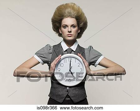 Stock Photograph - Businesswoman holding clock. Fotosearch