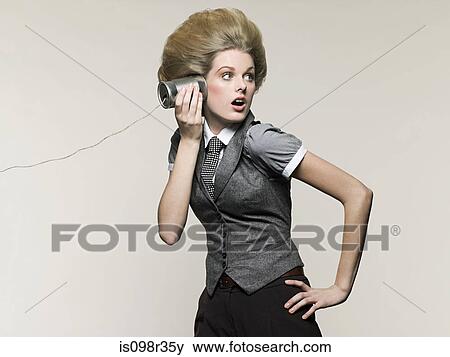 Stock Photo - Businesswoman on tin can phone. Fotosearch