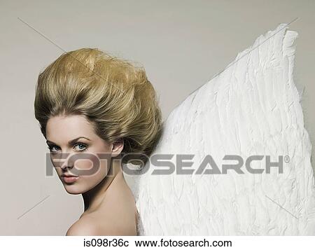 Stock Image - Young woman wearing angel wings. Fotosearch