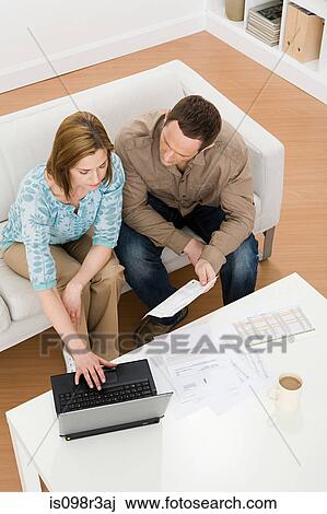 Stock Image - Couple sitting on couch. Fotosearch