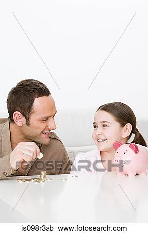 Stock Image - Father and daughter with piggy bank. Fotosearch