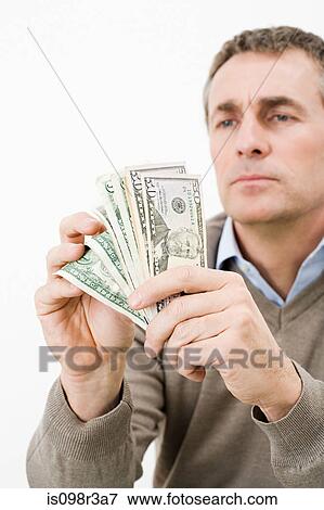 Stock Photo - Man holding money. Fotosearch