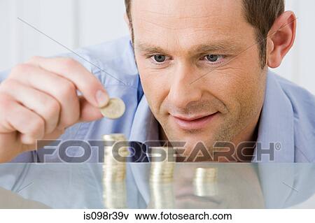 Man stacking coins View Large Photo Image Stock Photo - Man stacking coins. Fotosearch