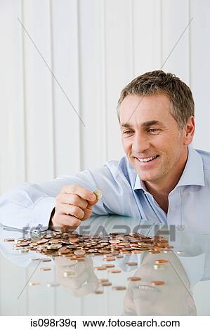 Stock Photography - Man with coins. Fotosearch