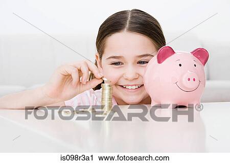 Stock Image - Young girl with piggy bank. Fotosearch