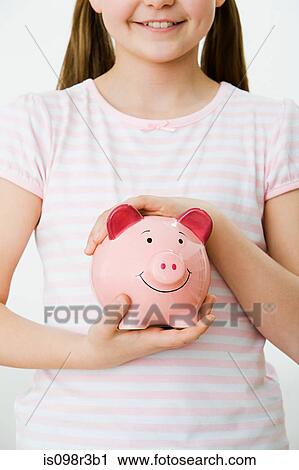 Stock Image - Young girl with piggy bank. Fotosearch