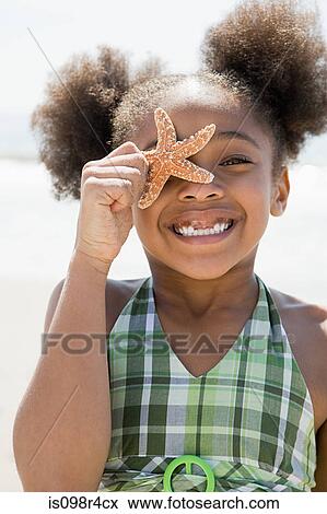 Stock Photo - Girl holding a starfish. Fotosearch