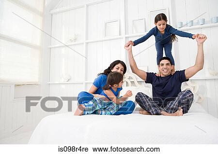 Stock Image - Hispanic family in a bedroom. Fotosearch