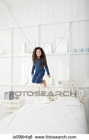 Hispanic girl jumping on bed View Large Photo Image Stock Photograph - Hispanic girl jumping on bed. Fotosearch