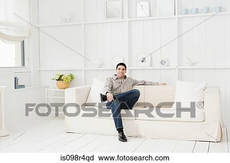 Hispanic man relaxing on a sofa View Large Photo Image Stock Image - Hispanic man relaxing on a sofa. Fotosearch