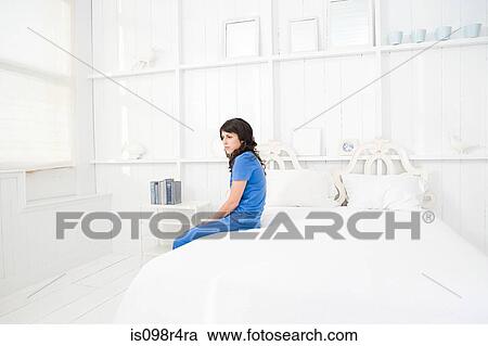 Lonely woman sitting on a bed View Large Photo Image Stock Image - Lonely woman sitting on a bed. Fotosearch