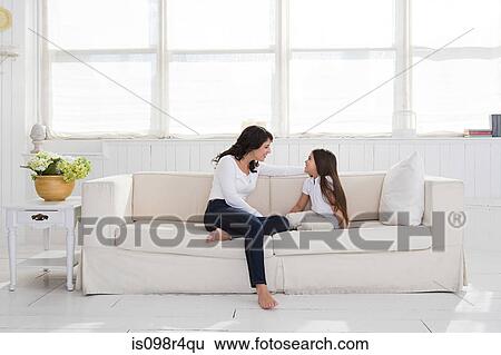 Mother and daughter sitting on a sofa View Large Photo Image Stock Photograph - Mother and daughter sitting on a sofa. Fotosearch