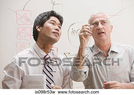Colleagues drawing diagram on glass View Large Photo Image Stock Photo - Colleagues drawing diagram on glass. Fotosearch
