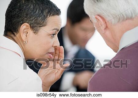 Stock Photo - Woman whispering in meeting. Fotosearch