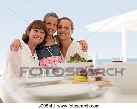Stock Image - Girl with grandmother and mother at meal. Fotosearch