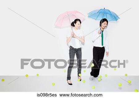 Couple with umbrellas and falling tennis balls View Large Photo Image Stock Photograph - Couple with umbrellas and falling tennis balls. Fotosearch