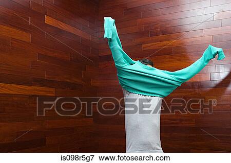Stock Photo - Man putting on sweater. Fotosearch