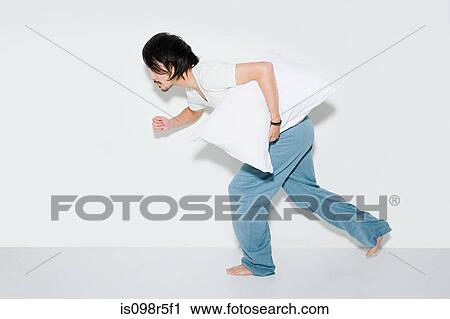 Man running with pillow View Large Photo Image Stock Image - Man running with pillow. Fotosearch