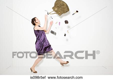 Woman and objects falling out of handbag View Large Photo Image Stock Image - Woman and objects falling out of handbag. Fotosearch