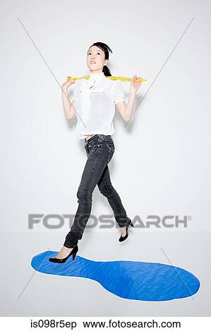 Woman jumping over puddle View Large Photo Image Stock Photography - Woman jumping over puddle. Fotosearch