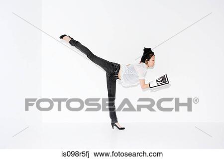 Woman on one leg with magazine View Large Photo Image Stock Image - Woman on one leg with magazine. Fotosearch