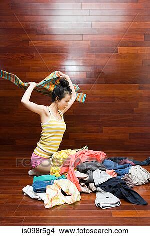 Woman throwing clothes View Large Photo Image Picture - Woman throwing clothes. Fotosearch