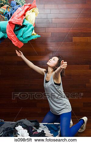Young woman throwing clothes View Large Photo Image Stock Photograph - Young woman throwing clothes. Fotosearch