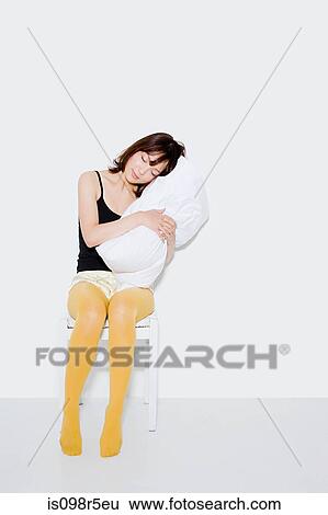 Stock Photograph - Young woman with pillow. Fotosearch